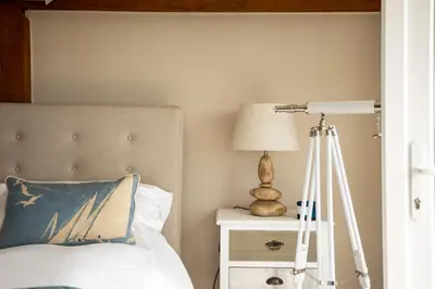 a bedroom with a bed with a lamp and a tripod at Trewartha in Penzance