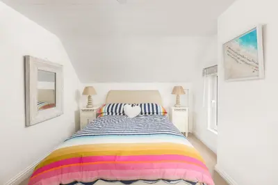 a bedroom with a bed with a colorful striped bedspread at Trewartha in Penzance