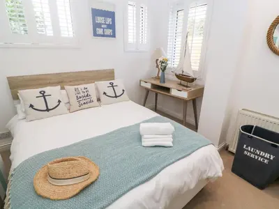 a bedroom with a bed with a straw hat on it at Trewartha in Penzance