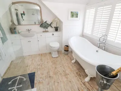 a bathroom with a tub and a toilet and a sink at Trewartha in Penzance