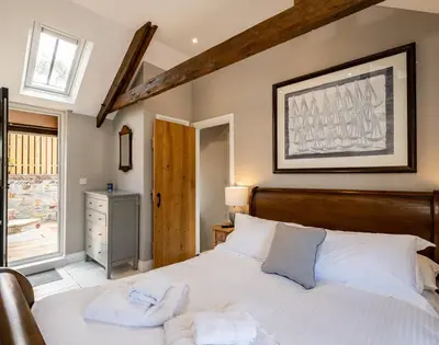 a bedroom with a large bed with towels on it at Mino Cottage in Port Isaac