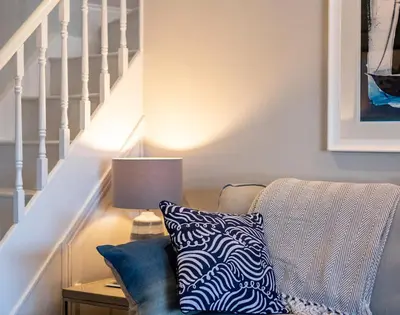 a living room with a couch and a table with a lamp at Mino Cottage in Port Isaac