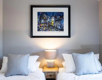 a painting on the wall above two beds in a bedroom at Mino Cottage in Port Isaac
