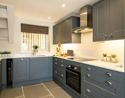 a kitchen with blue cabinets and white counter tops at Mino Cottage in Port Isaac