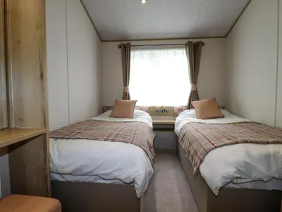 two beds in a small room with a window at Beachcliff in Newquay