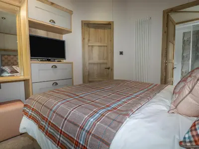 a bedroom with a bed with a tv on it at Beachcliff in Newquay