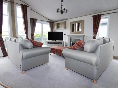a living room with two chairs and a television at Beachcliff in Newquay