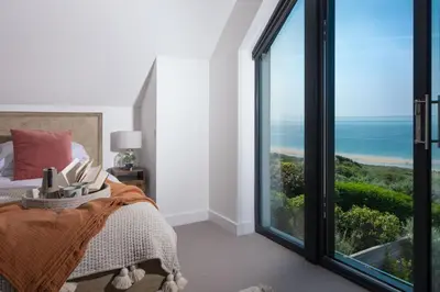 a bedroom with a bed with a view of the ocean at Ocean View, The Sands in Praa Sands