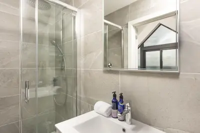 a bathroom with a sink and a shower and a mirror at Ocean View, The Sands in Praa Sands