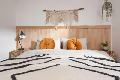 a bedroom with a large white bed with orange pillows at Ocean View, The Sands in Praa Sands