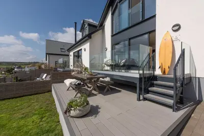 a house with a deck with a surfboard on it at Ocean View, The Sands in Praa Sands