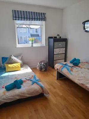 a bedroom with two twin beds and a window at Fistral beach apartment in Newquay