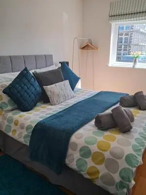 a large bed with pillows on it in a bedroom at Fistral beach apartment in Newquay