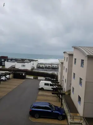 a car parked in a parking lot next to a building at Fistral beach apartment in Newquay