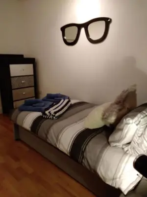 a bedroom with a bed with glasses on the wall at Fistral beach apartment in Newquay