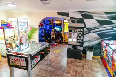 a game room with a pinball machine and a arcade at Camping Pods Trevella Holiday Park in Crantock