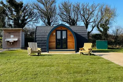 two chairs in front of a tiny house at Camping Pods Trevella Holiday Park in Crantock