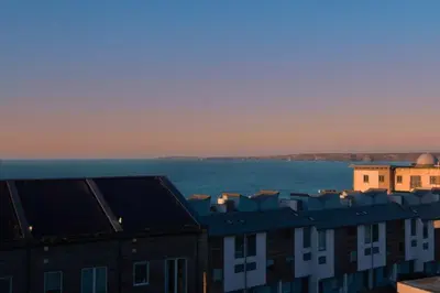 a view of roofs of buildings and a body of water at Trevose Penthouse in Newquay