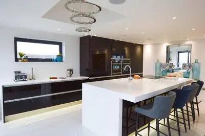 a kitchen with a white counter and black cabinets at Trevose Penthouse in Newquay