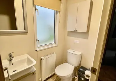 a small bathroom with a toilet and a sink at Luxury 3 bedroom caravan between Perranporth and Newquay, Cornwall in Newquay