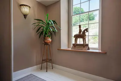 a room with a plant and a statue in a window at Cusgarne Manor boutique B&B - adults only in Cusgarne
