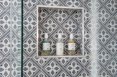 a shelf with bottles on it in a bathroom at Cusgarne Manor boutique B&B - adults only in Cusgarne