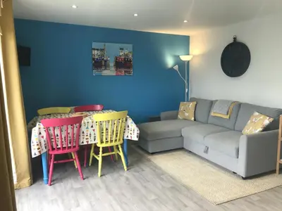 a living room with a couch and a table and chairs at Kingfisher Glamping Cabin in Bodmin