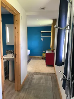 a bathroom with a blue wall and a sink at Kingfisher Glamping Cabin in Bodmin