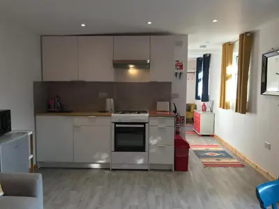 a kitchen with stainless steel appliances and white cabinets at Woodpecker Glamping Cabin in Bodmin