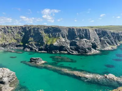 an aerial view of the ocean with a cliff at Toms Hut and Robins Rest Shepherd Huts near Wadebridge in Wadebridge