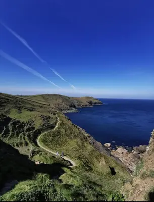 an aerial view of a path on a hill next to the ocean at Toms Hut and Robins Rest Shepherd Huts near Wadebridge in Wadebridge