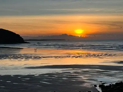 a sunset on the beach with the sun setting at Toms Hut and Robins Rest Shepherd Huts near Wadebridge in Wadebridge
