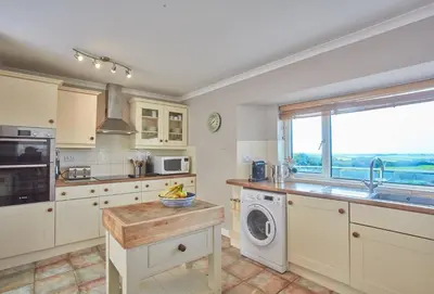 a kitchen with a sink and a washing machine at Seawynds in Port Isaac