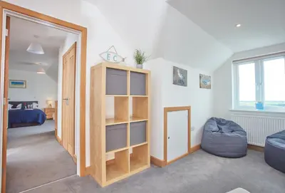 a living room with a book shelf and a couch at Seawynds in Port Isaac