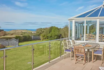 a balcony with a table and chairs and a gazebo at Seawynds in Port Isaac