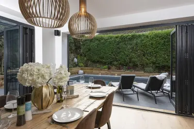 a dining room with a table and chairs and plants at Chy An Eglos - Private pool and Hot tub in Carbis Bay