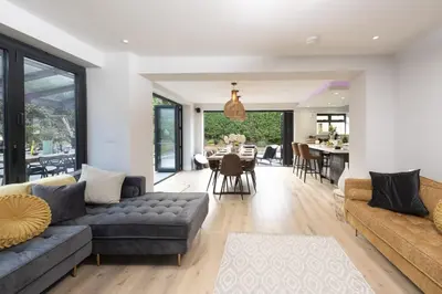 a living room with a couch and a table at Chy An Eglos - Private pool and Hot tub in Carbis Bay