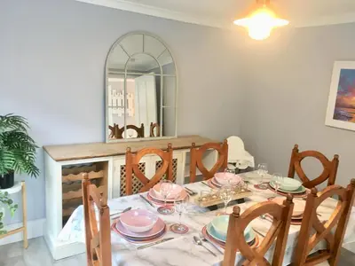 a dining room with a table with chairs and a mirror at The Old Bark House No 3 in Mevagissey