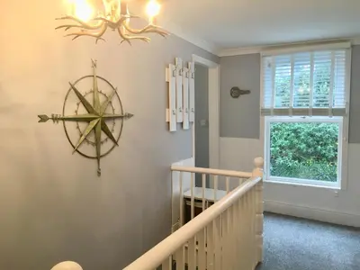 a staircase in a home with a large clock on the wall at The Old Bark House No 3 in Mevagissey