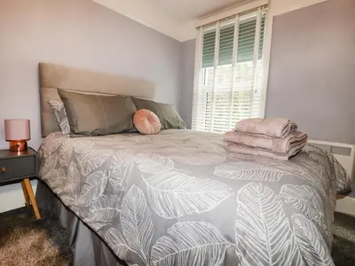 a bedroom with a large bed with a large window at The Old Bark House No 3 in Mevagissey