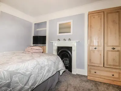 a bedroom with a bed and a fireplace at The Old Bark House No 3 in Mevagissey