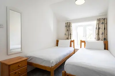 a bedroom with two beds and a window at Hengar Manor Apartments in Michaelstow