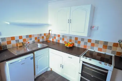 a kitchen with white cabinets and a sink at Hengar Manor Apartments in Michaelstow