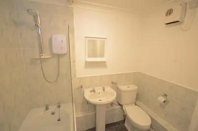a bathroom with a toilet and a sink and a shower at Hengar Manor Apartments in Michaelstow
