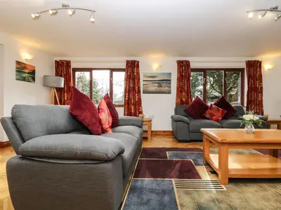 a living room with two couches and a table at South Boduel Farmhouse in Liskeard