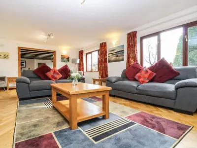 a living room with two couches and a table at South Boduel Farmhouse in Liskeard