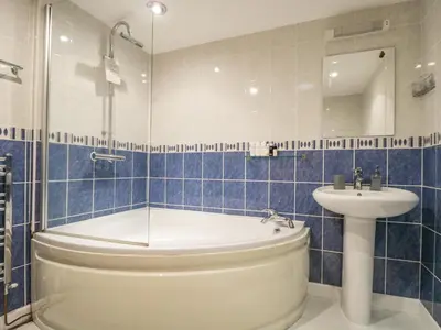 a bathroom with a tub and a sink at South Boduel Farmhouse in Liskeard