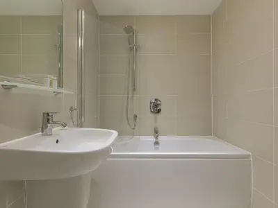 a bathroom with a sink and a tub and a shower at The Lighthouse in St Ives