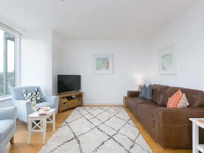 a living room with a brown couch and a tv at The Lighthouse in St Ives