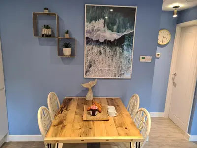 a dining room with a wooden table and chairs at Pebble Cottage in Uny Lelant
